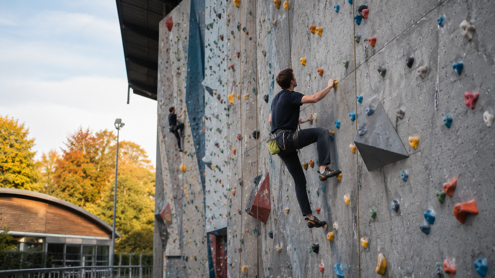 Young climber considering the next route on an outdoor British climbing wall.